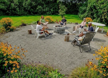 Outdoor group session around the fire pit surrounded by flowers